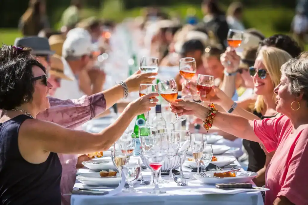 People Clinking Glasses Sitting Down at the Araxi Longtable Dinner Series at North Arm Farms